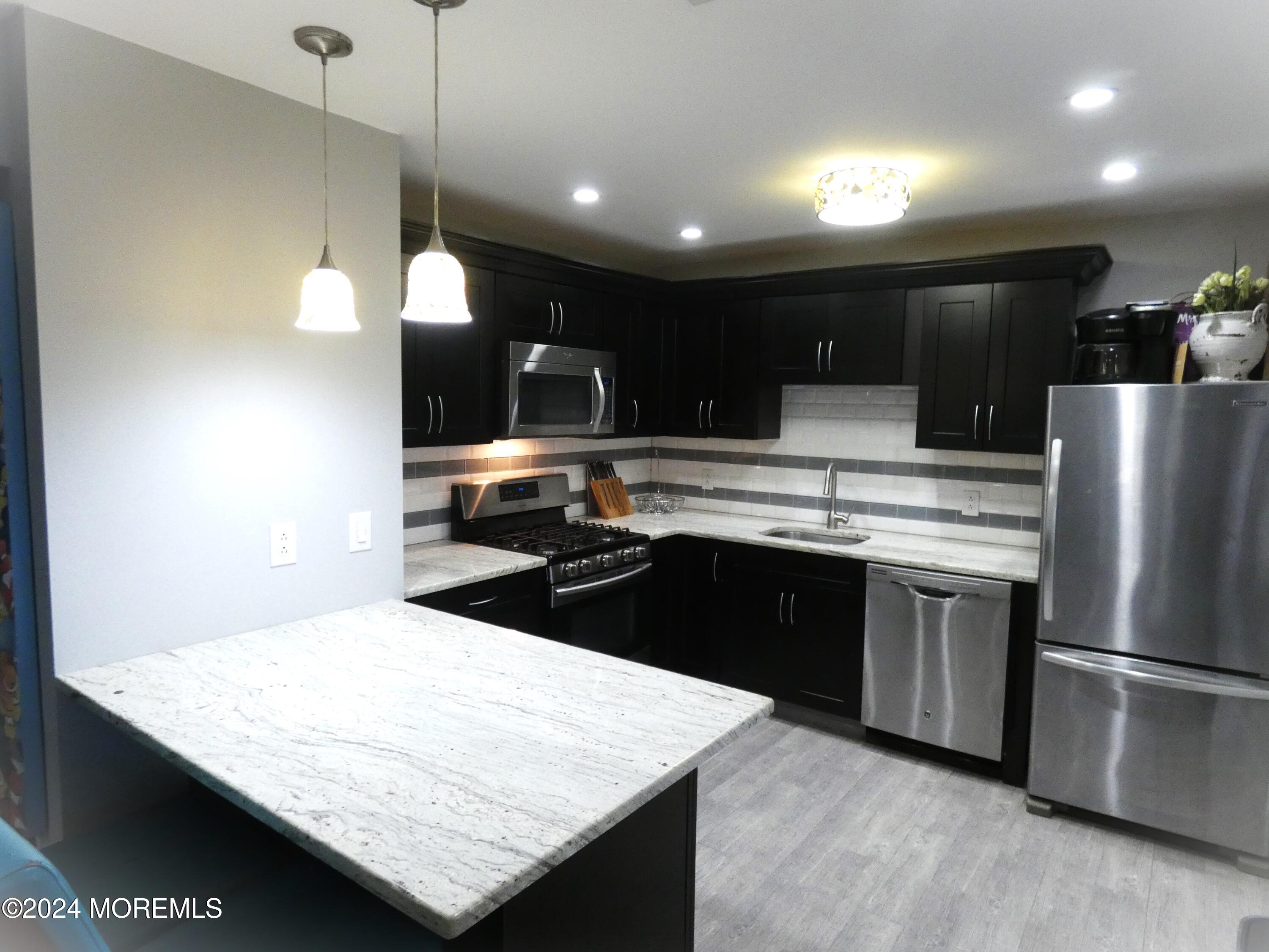 a kitchen with a sink a counter top space and stainless steel appliances