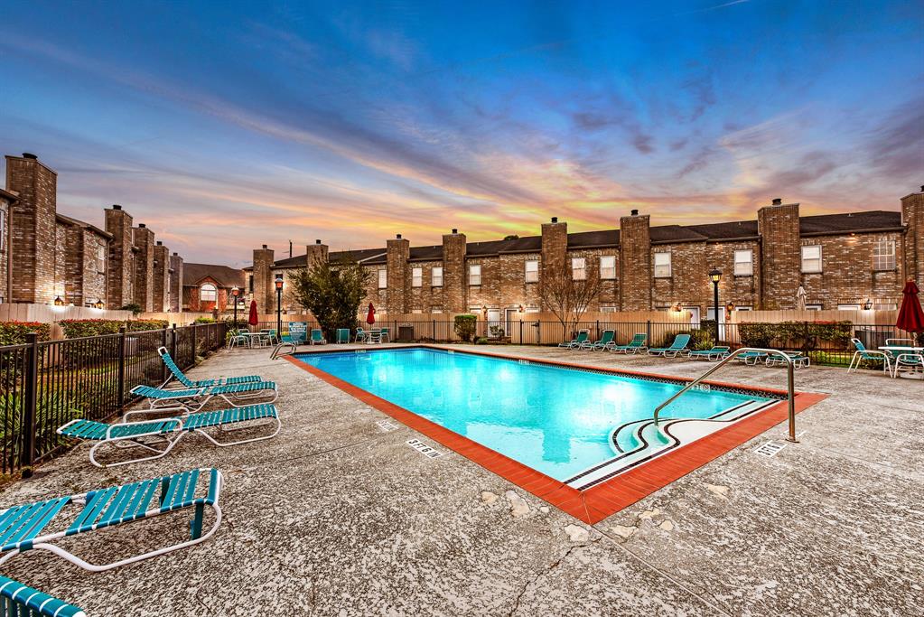 an outdoor space with swimming pool and furniture