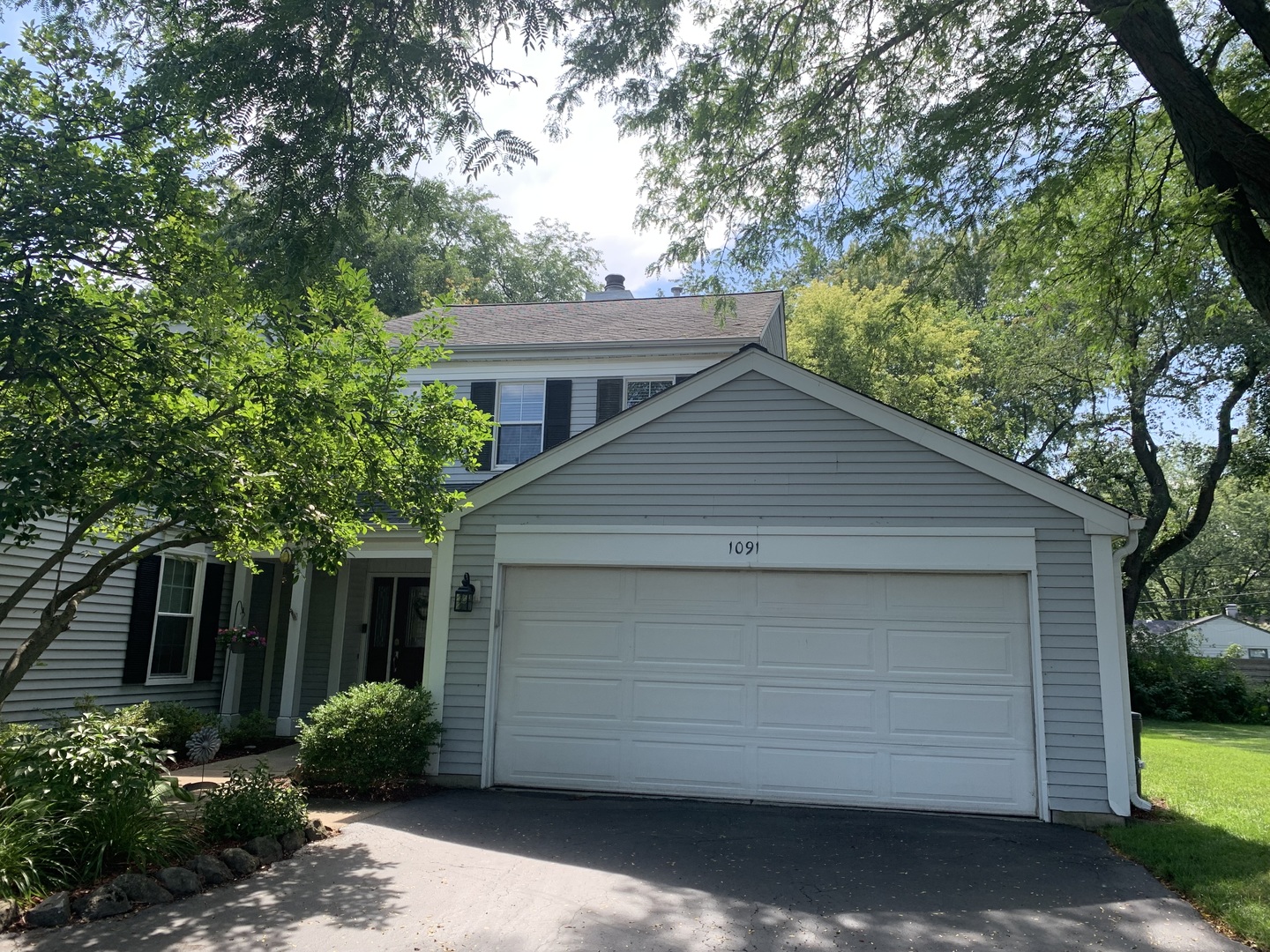 a front view of house with trees around