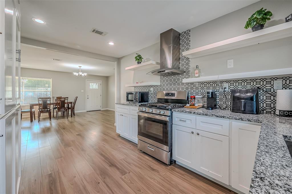 The overall combination of white cabinetry, bold backsplash, and high-quality appliances creates a sophisticated kitchen that is both functional and visually appealing.