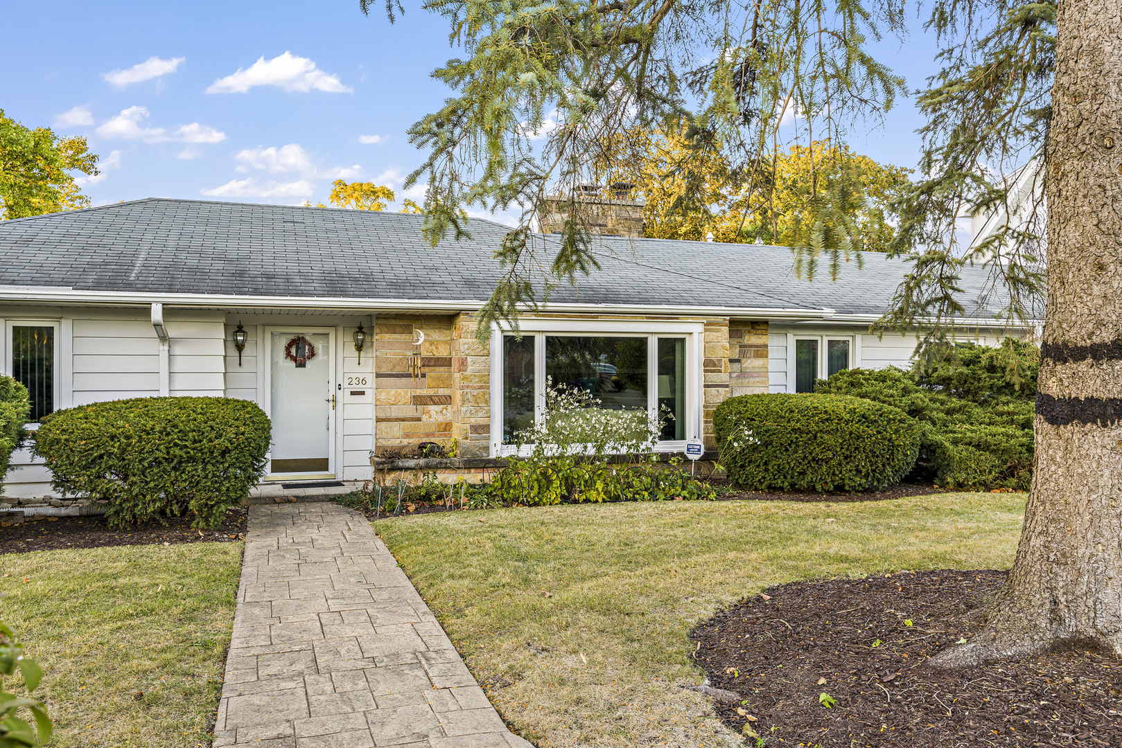 a front view of a house with yard patio and green space