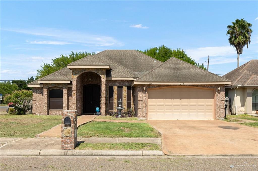 View of front of home featuring a front yard and a garage