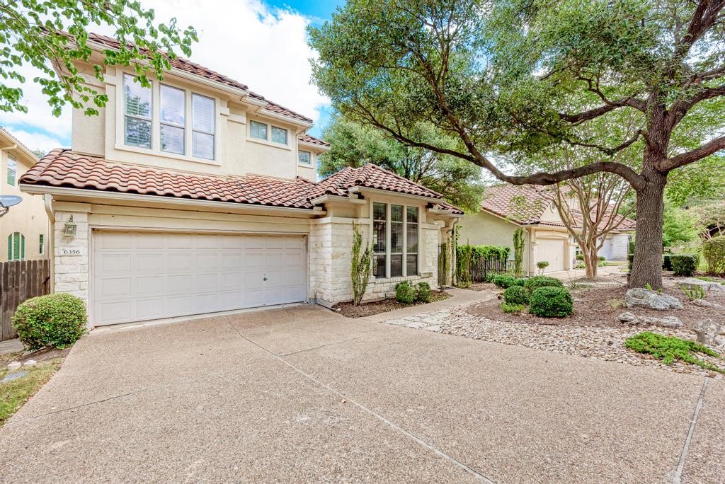 a view of a house with a patio and a yard