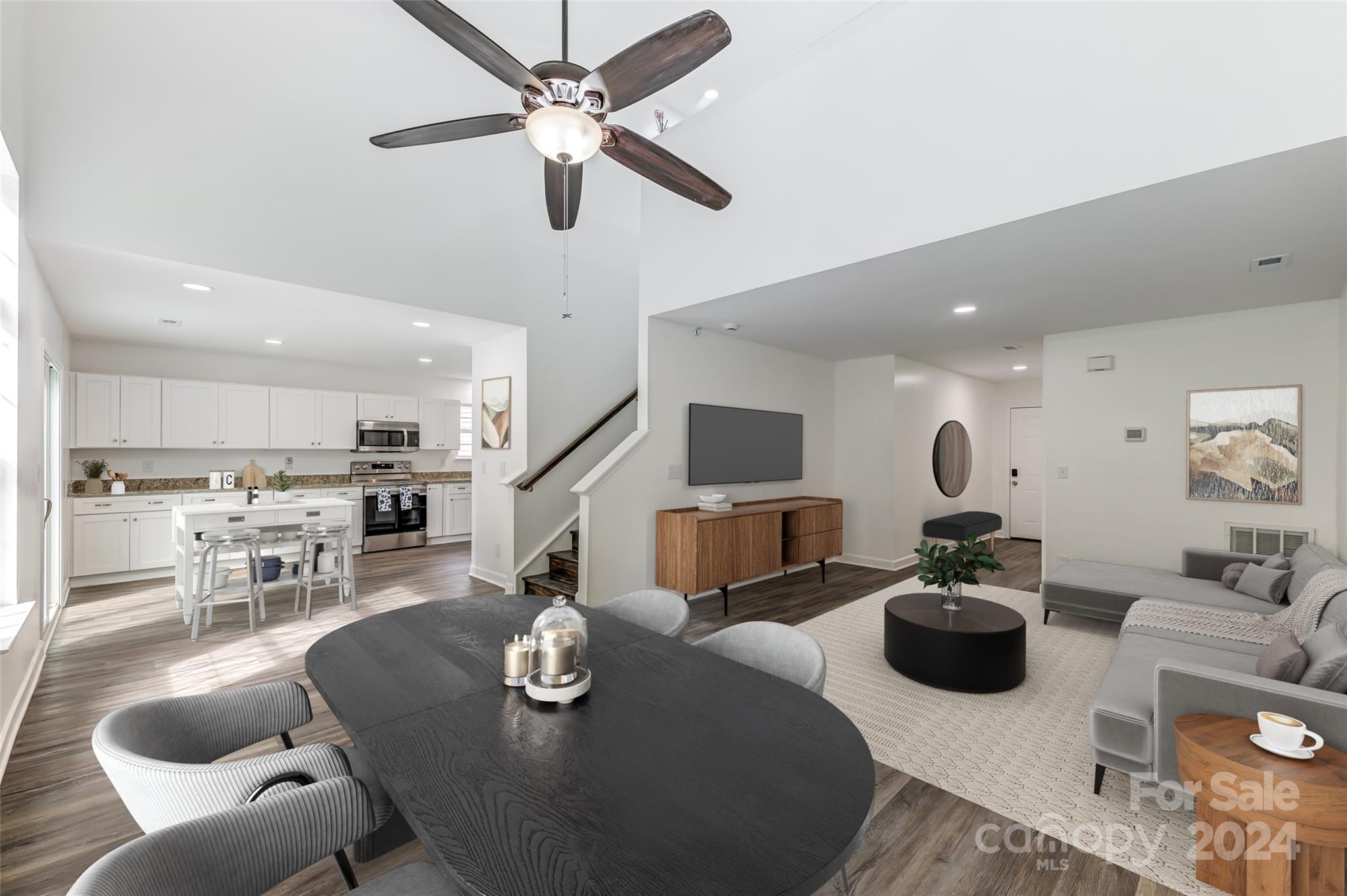 a living room with furniture kitchen view and a wooden floor