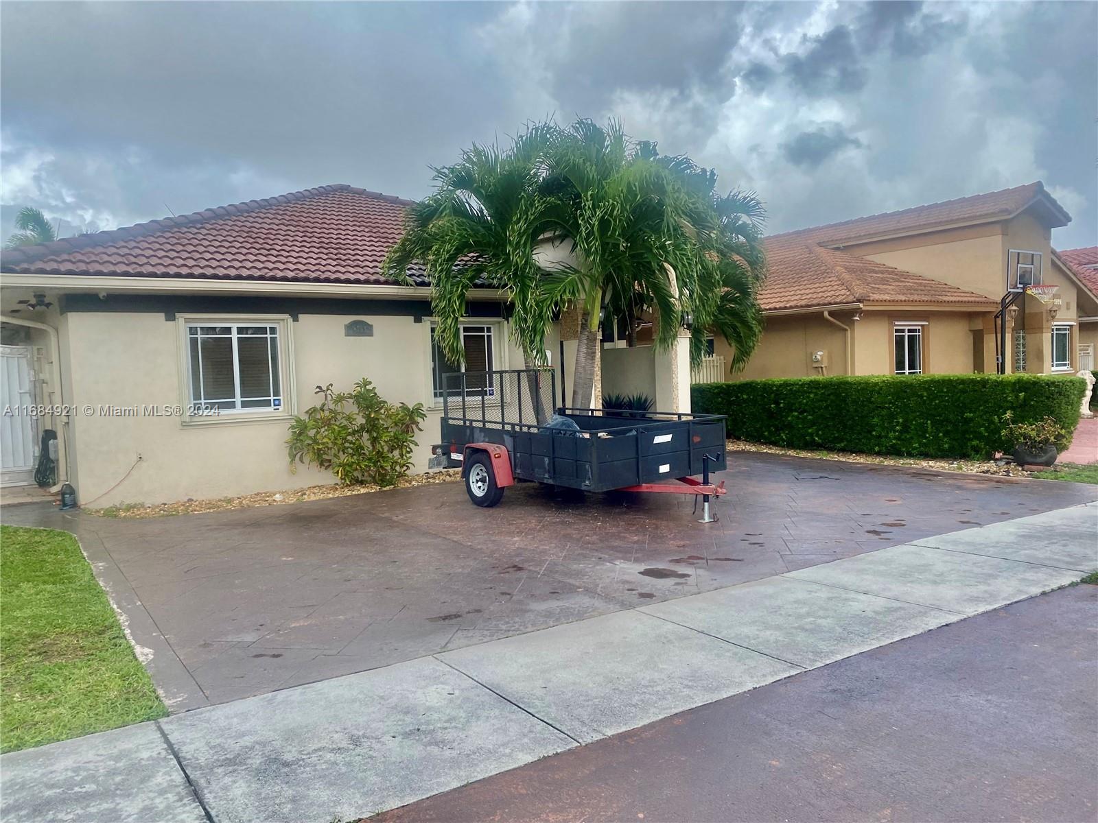 a view of a house with a yard and palm tree