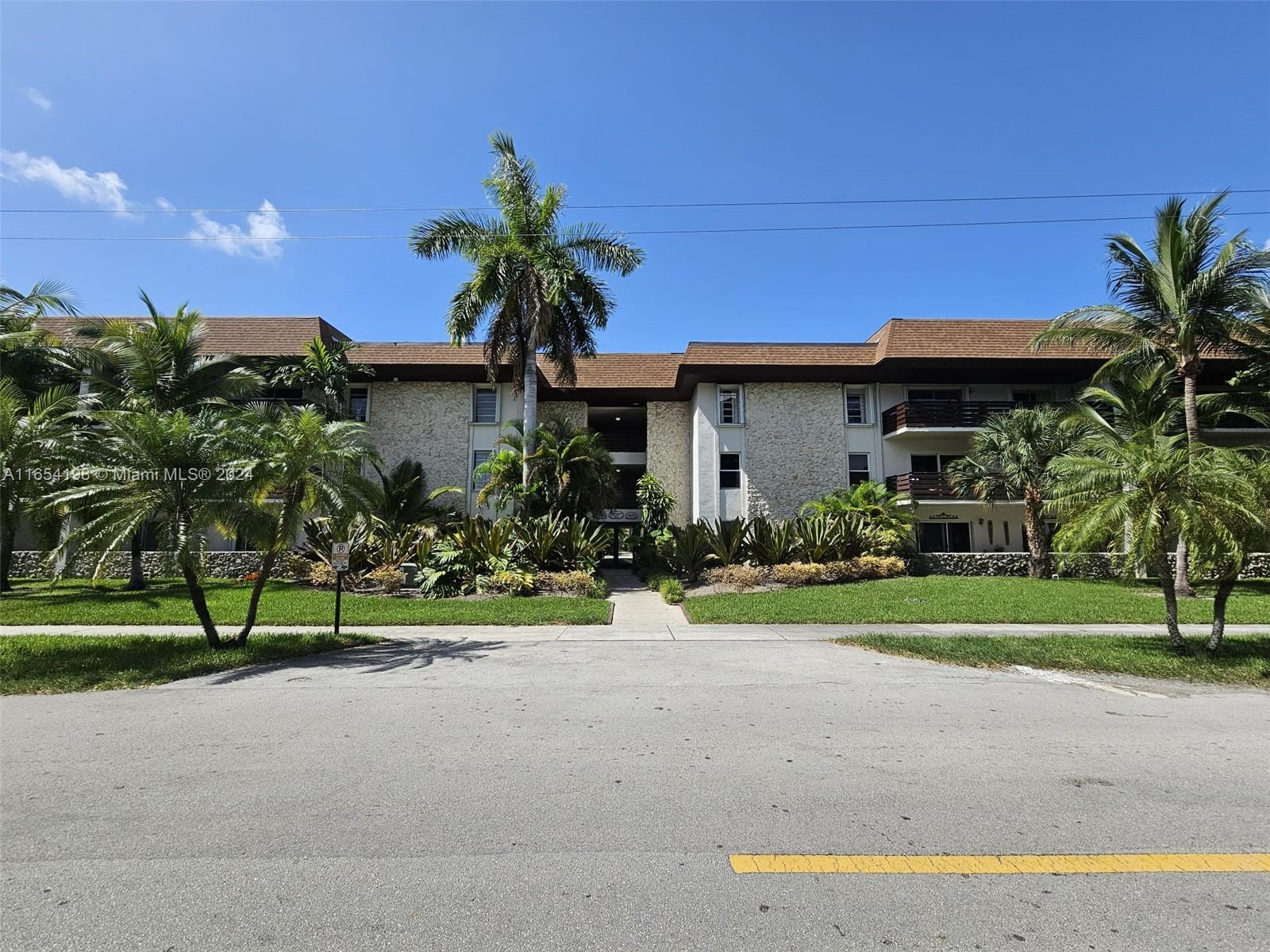 a palm tree sitting in front of a house with a yard