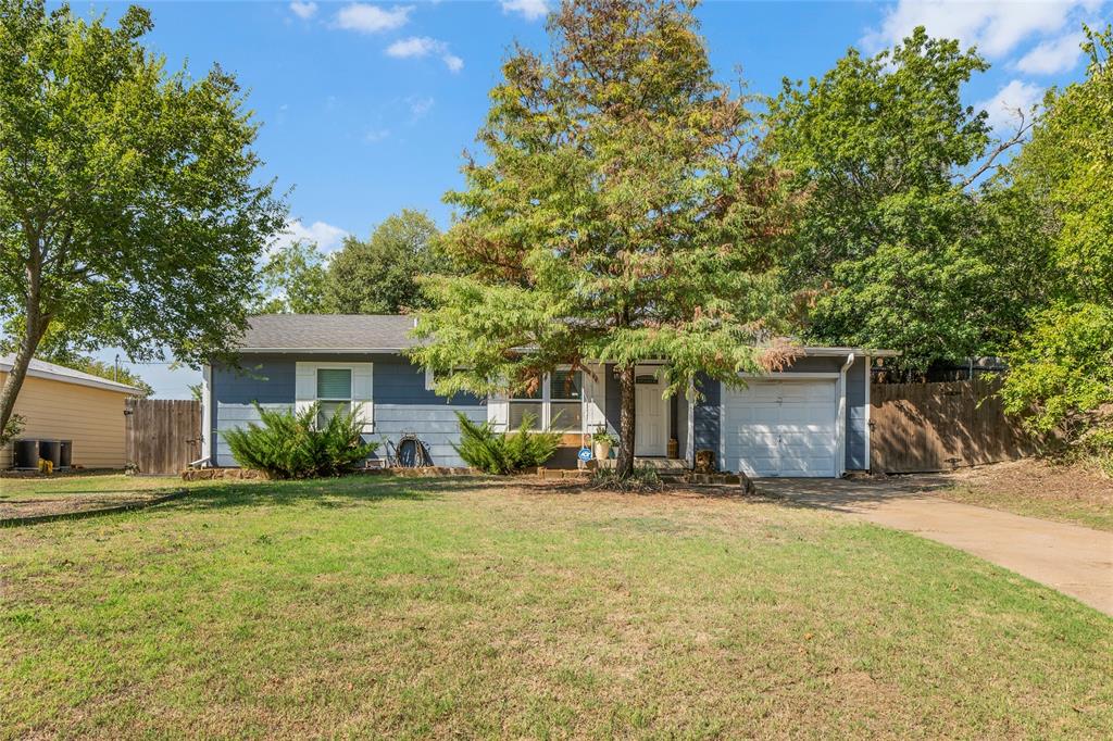 a front view of a house with a yard and trees