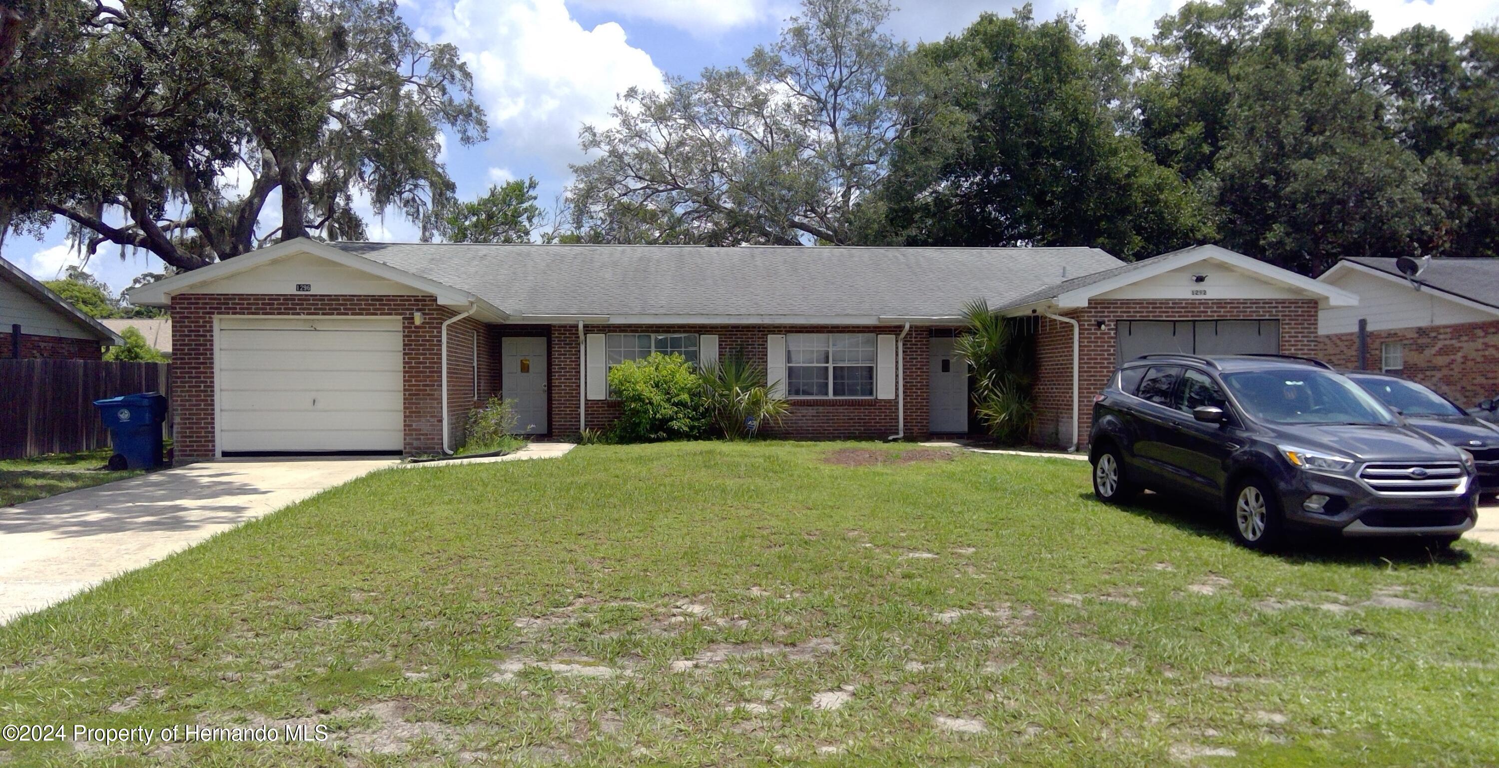 a front view of a house with a garden and trees