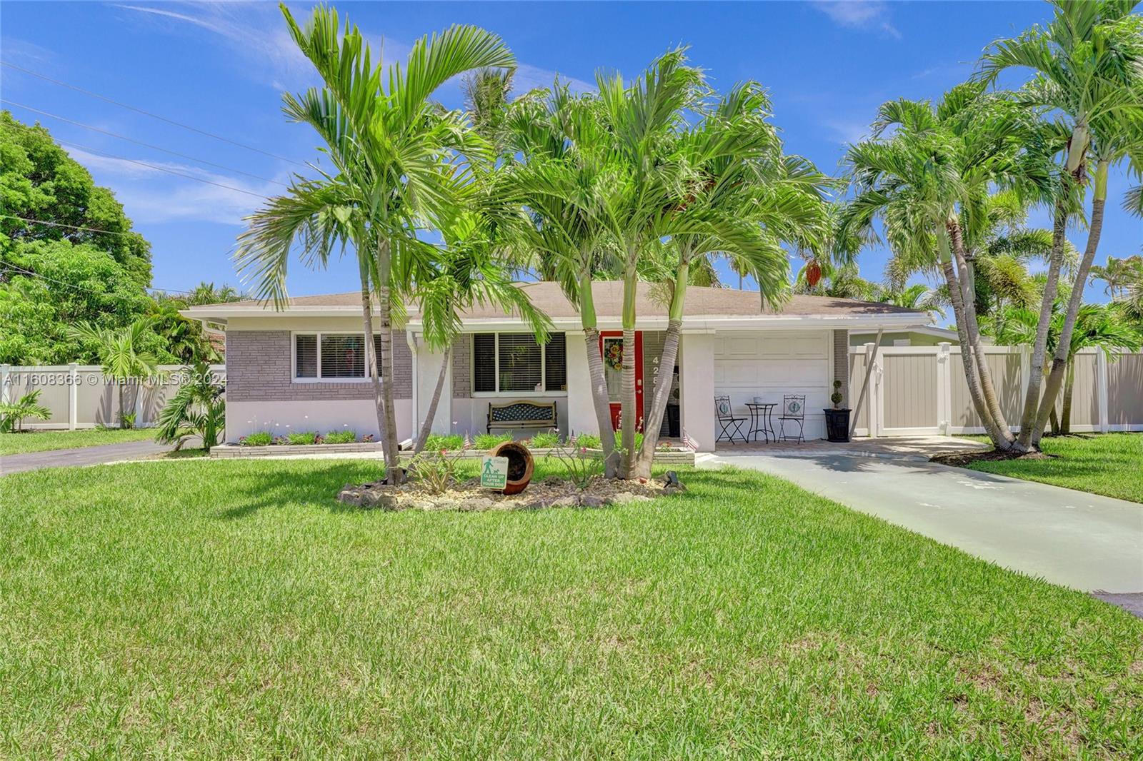 a view of a house with a yard and palm trees