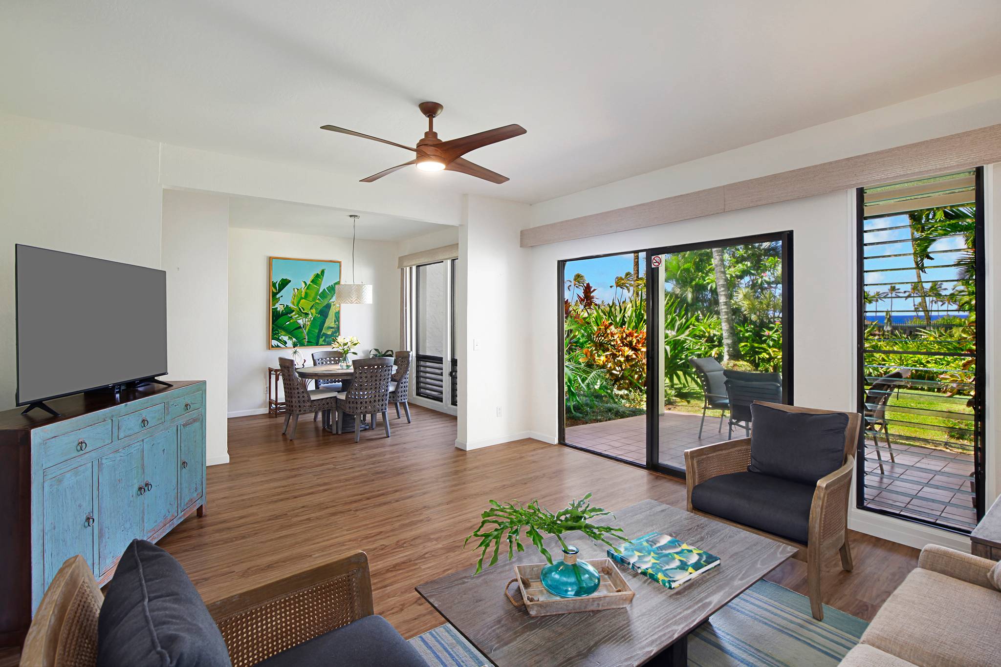 a living room with furniture a flat screen tv and a large window