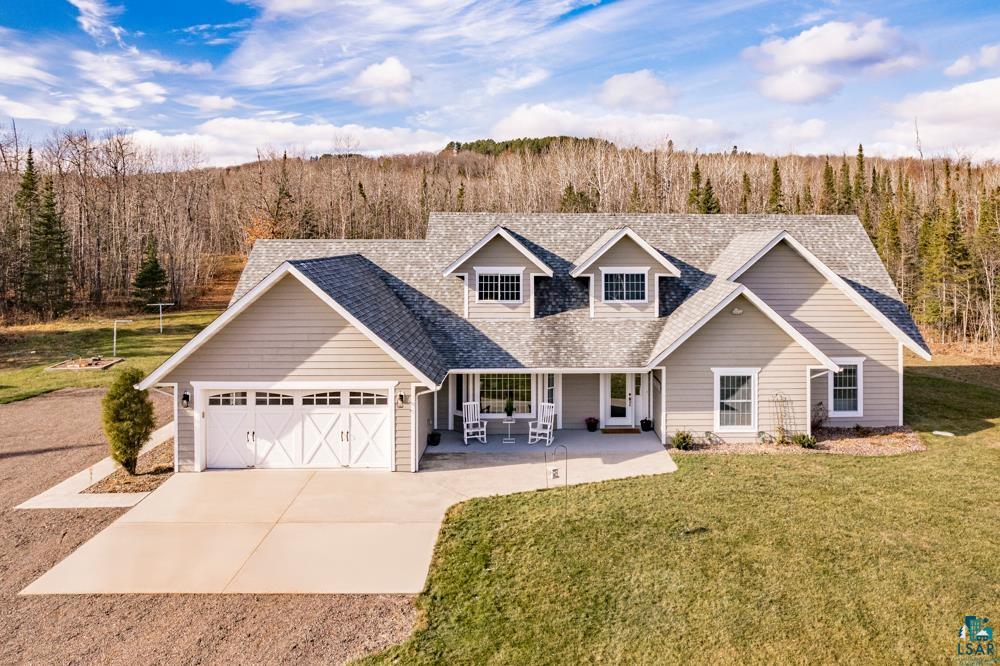 View of front of home featuring a front yard, a garage, and a porch