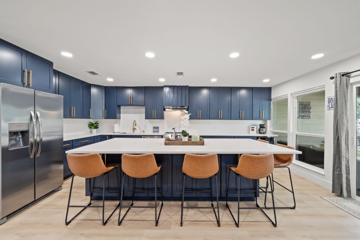 a large kitchen with a table and chairs