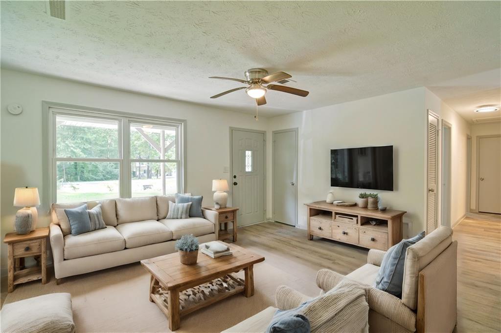 a living room with furniture a flat screen tv and a large window