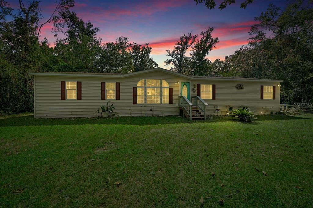 a front view of house with yard and green space