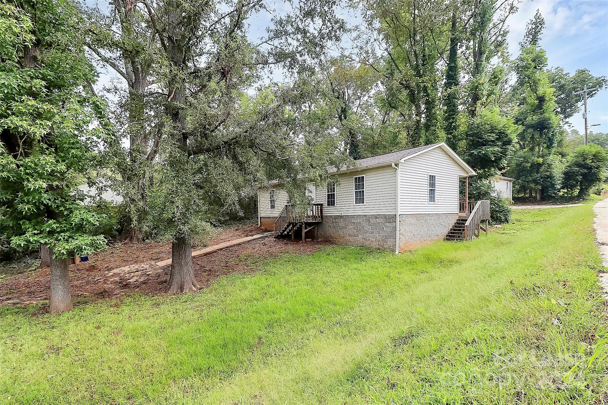 a view of a house with backyard and a tree