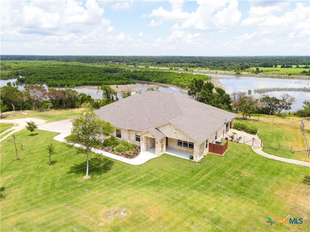 a view of a house with a yard and lake view