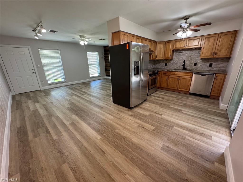 a kitchen with stainless steel appliances granite countertop a refrigerator and a sink