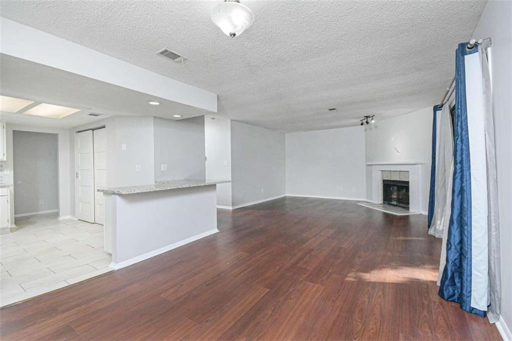 an empty room with wooden floor and fireplace