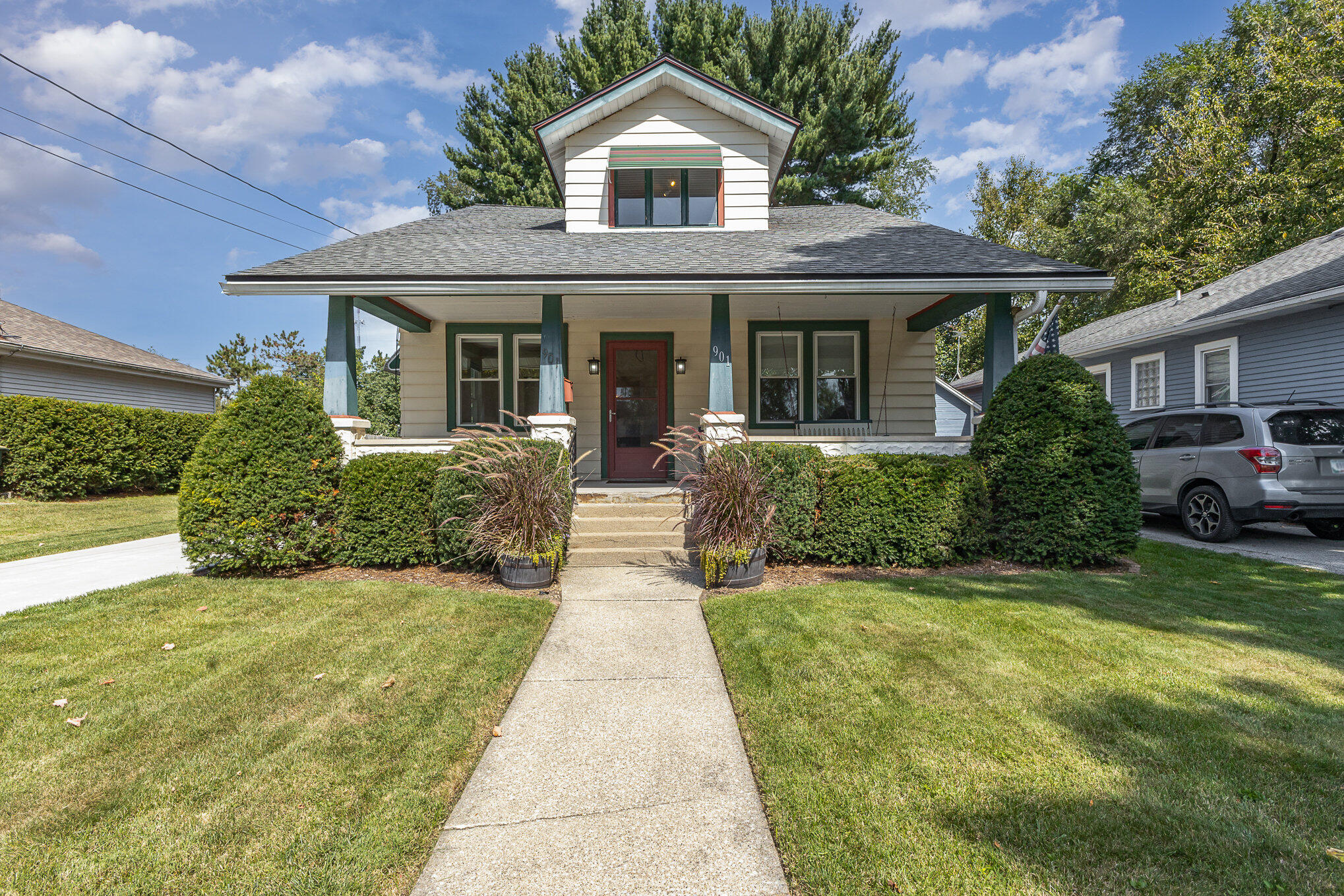 a front view of a house with a yard and potted plants