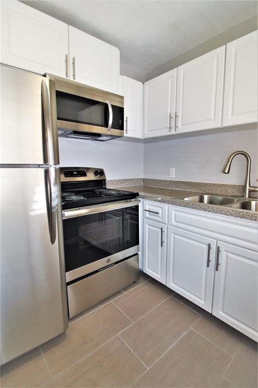 a kitchen with cabinets stainless steel appliances and sink