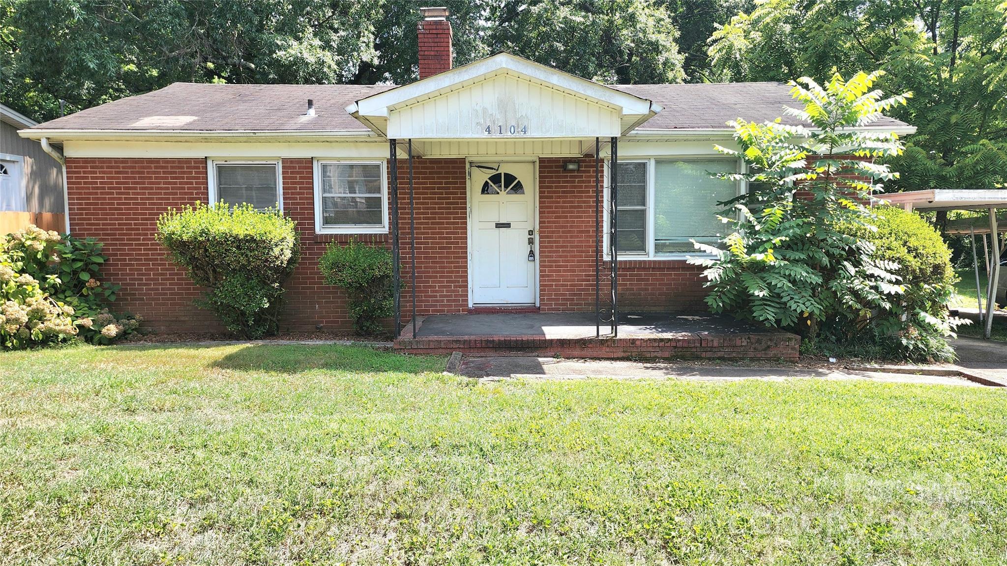 a front view of a house with a garden and plants