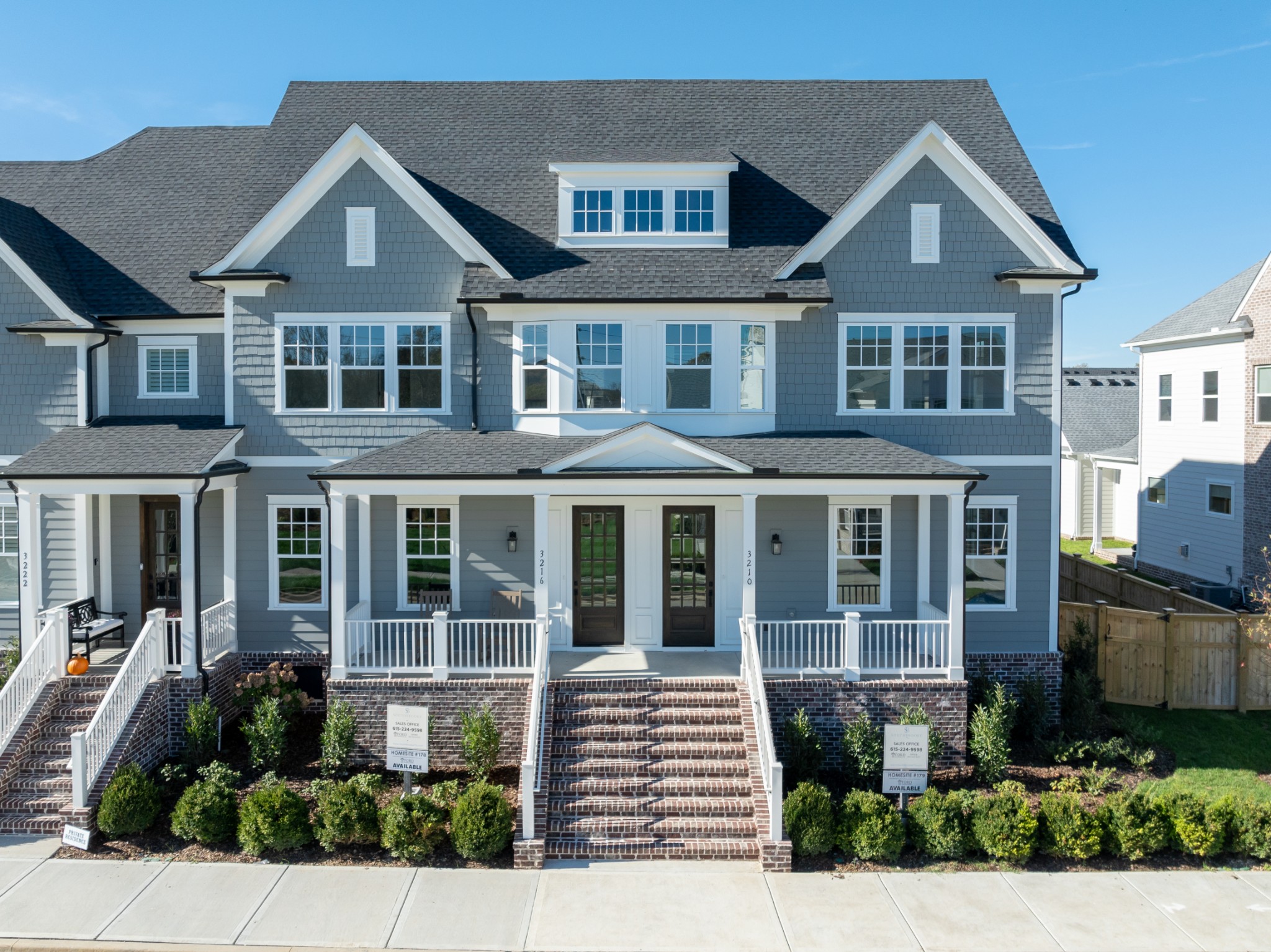 a front view of a house with a yard and potted plants