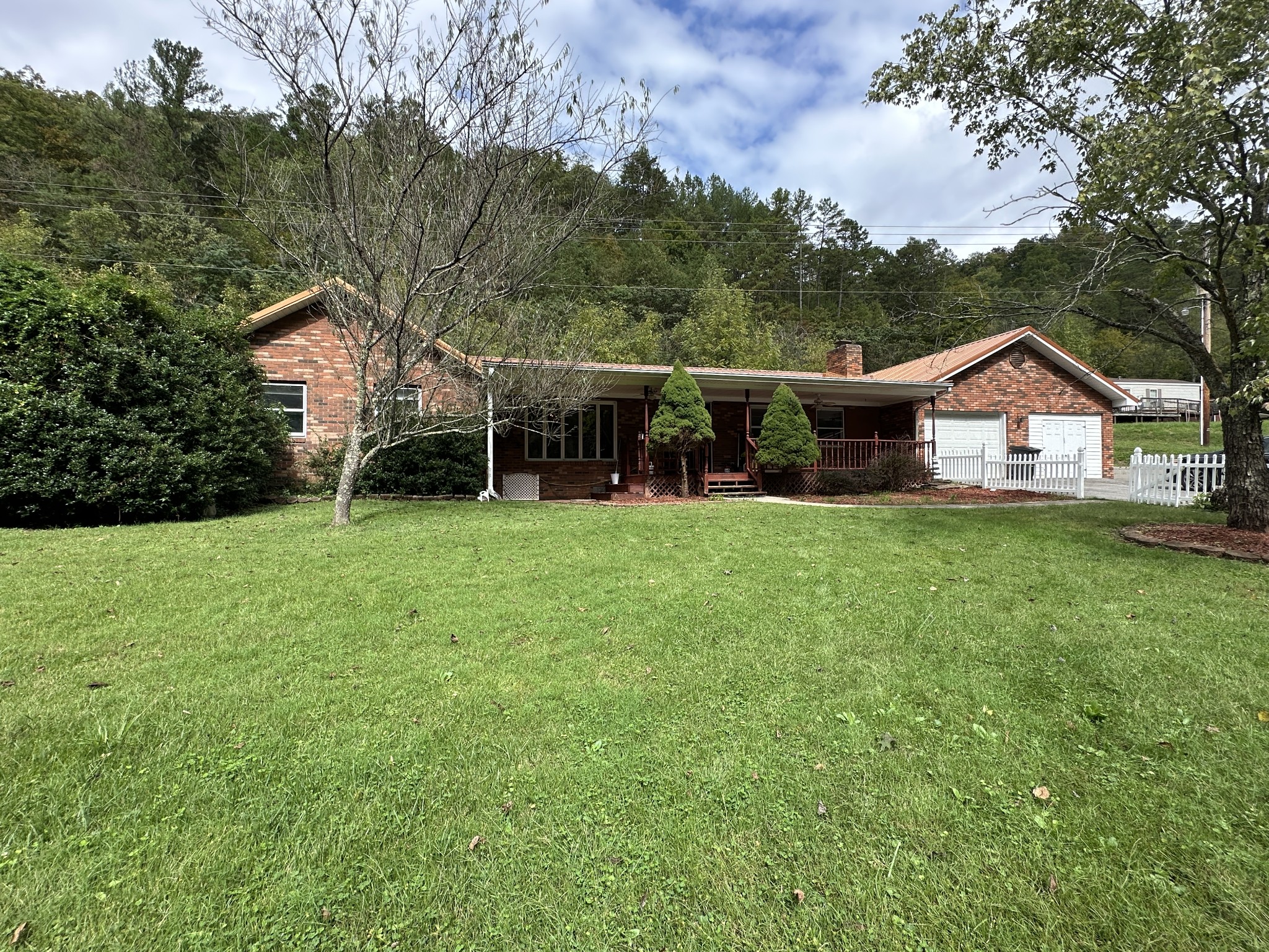 a view of a house with a big yard and large trees