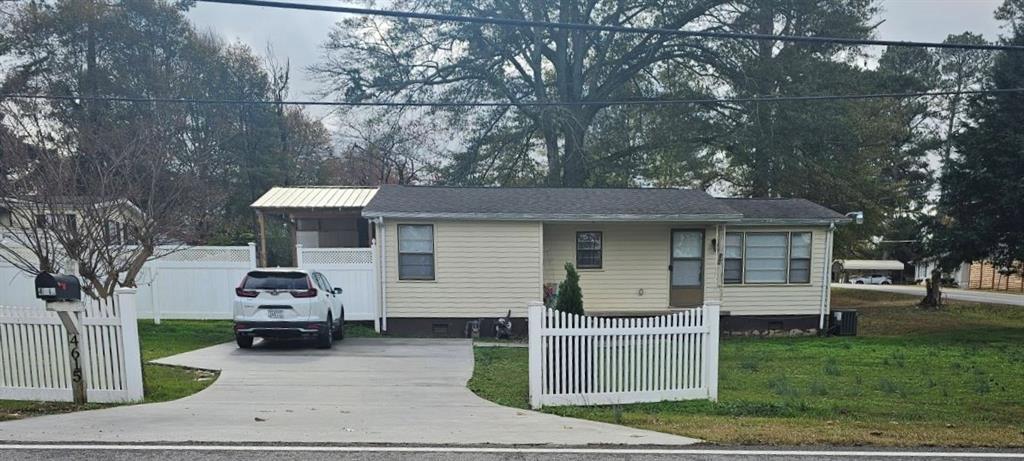 a front view of a house with a garden and trees