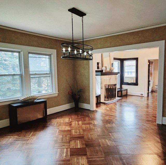 a view of a livingroom with wooden floor and a ceiling fan