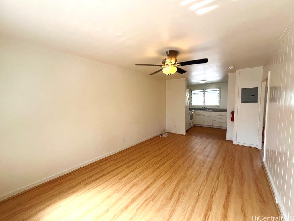 a view of an empty room with a window and wooden floor