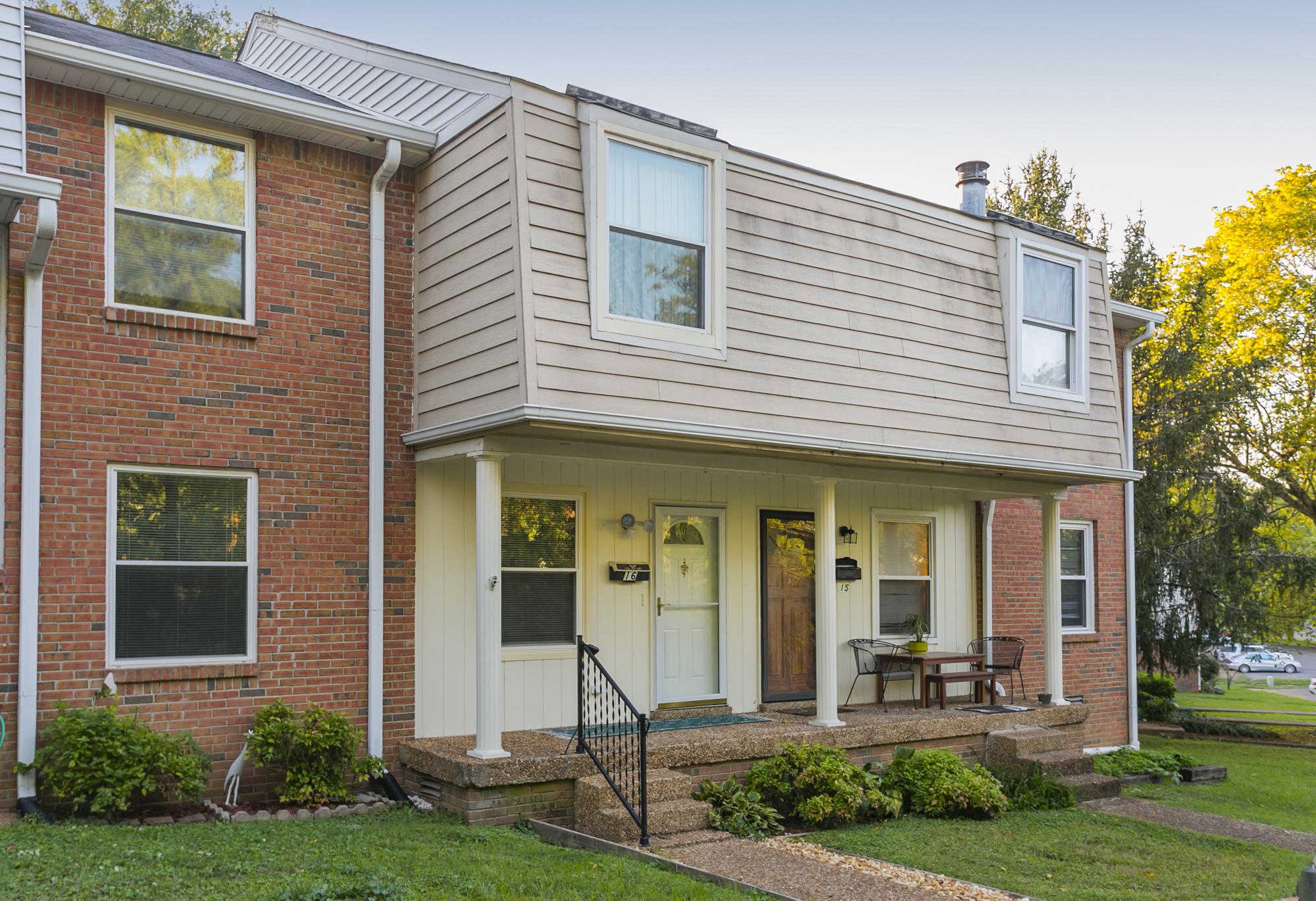 a front view of a house with a yard and table and chairs in patio