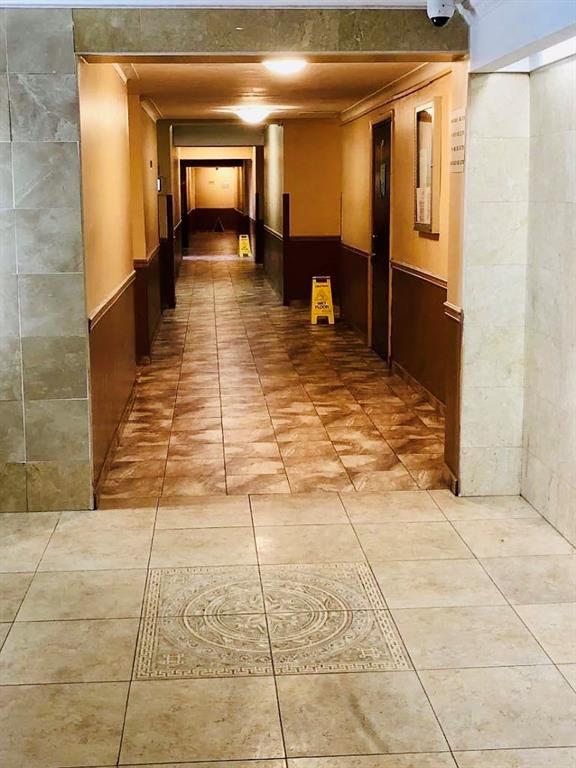 a view of a hallway with wooden floor and livingroom view