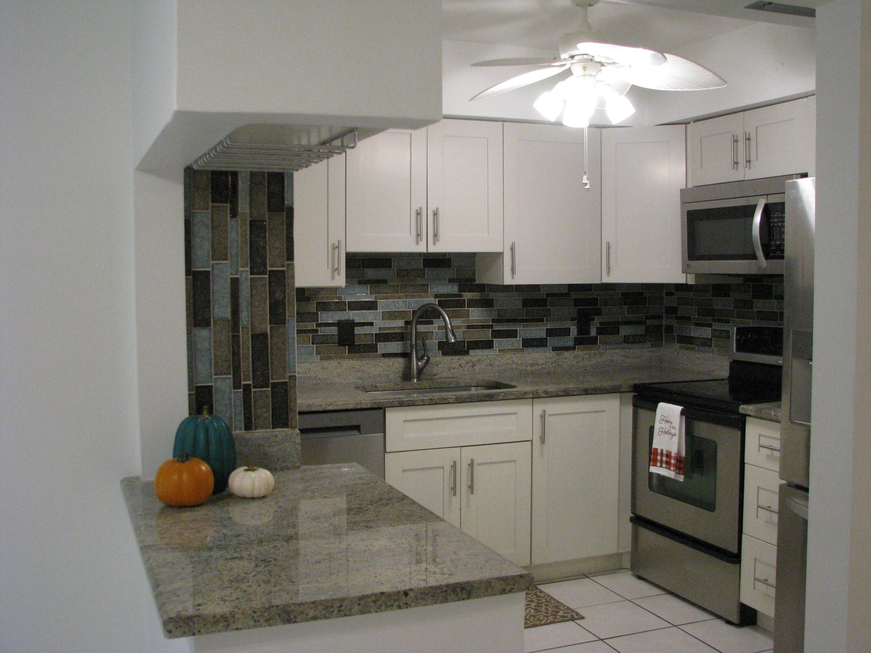 a kitchen with stainless steel appliances granite countertop a sink and a stove