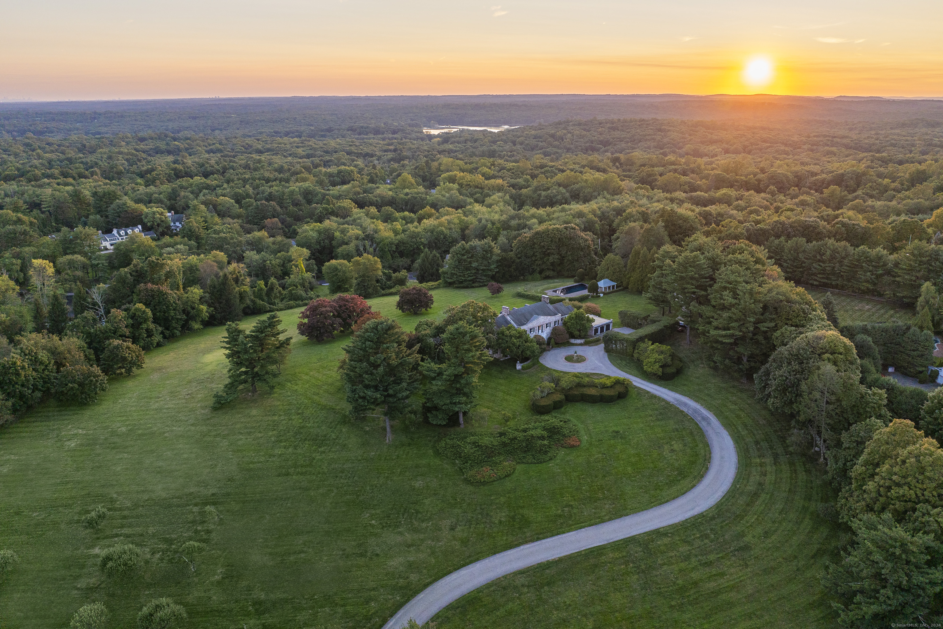 an aerial view of residential houses with outdoor space and trees