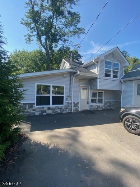 a front view of a house with yard and parking