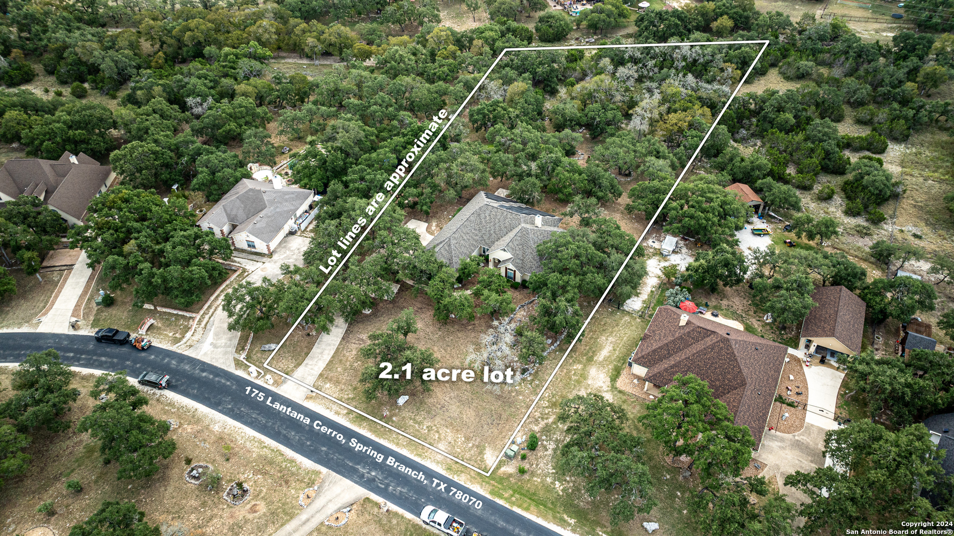 an aerial view of residential houses with outdoor space and trees around