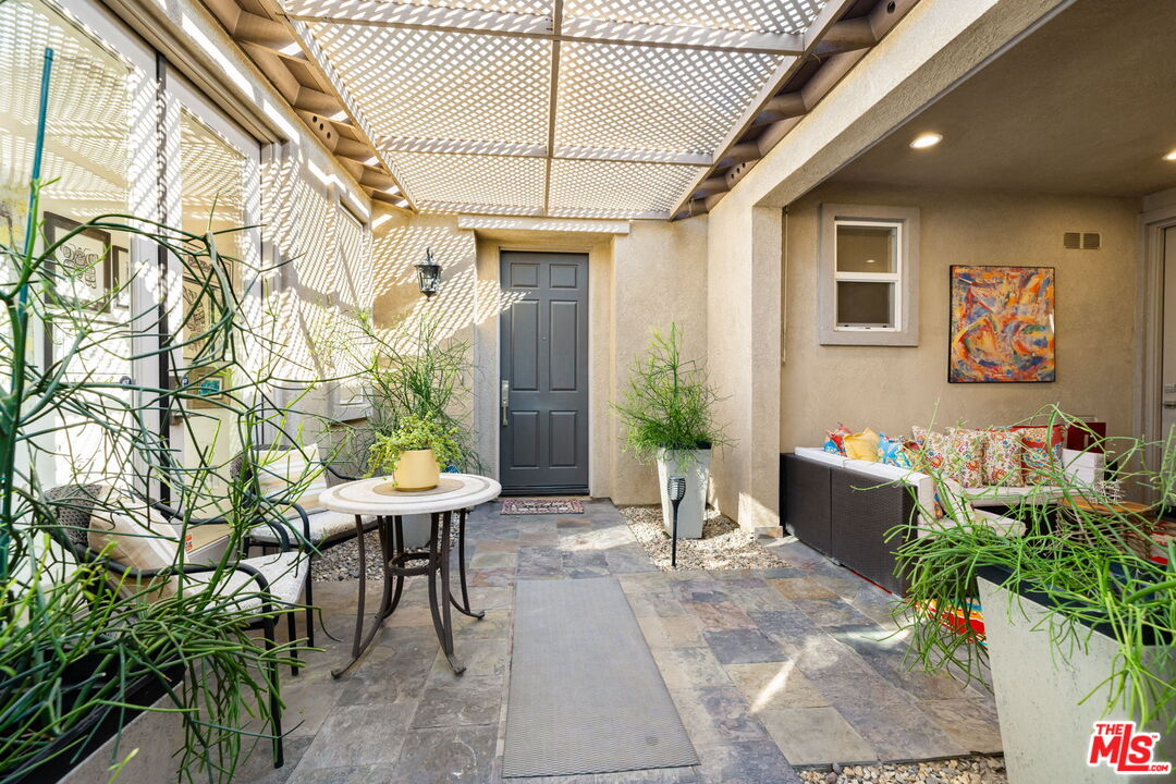 a view of a patio with table and chairs and potted plants