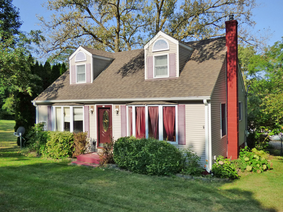 a front view of a house with a yard and trees