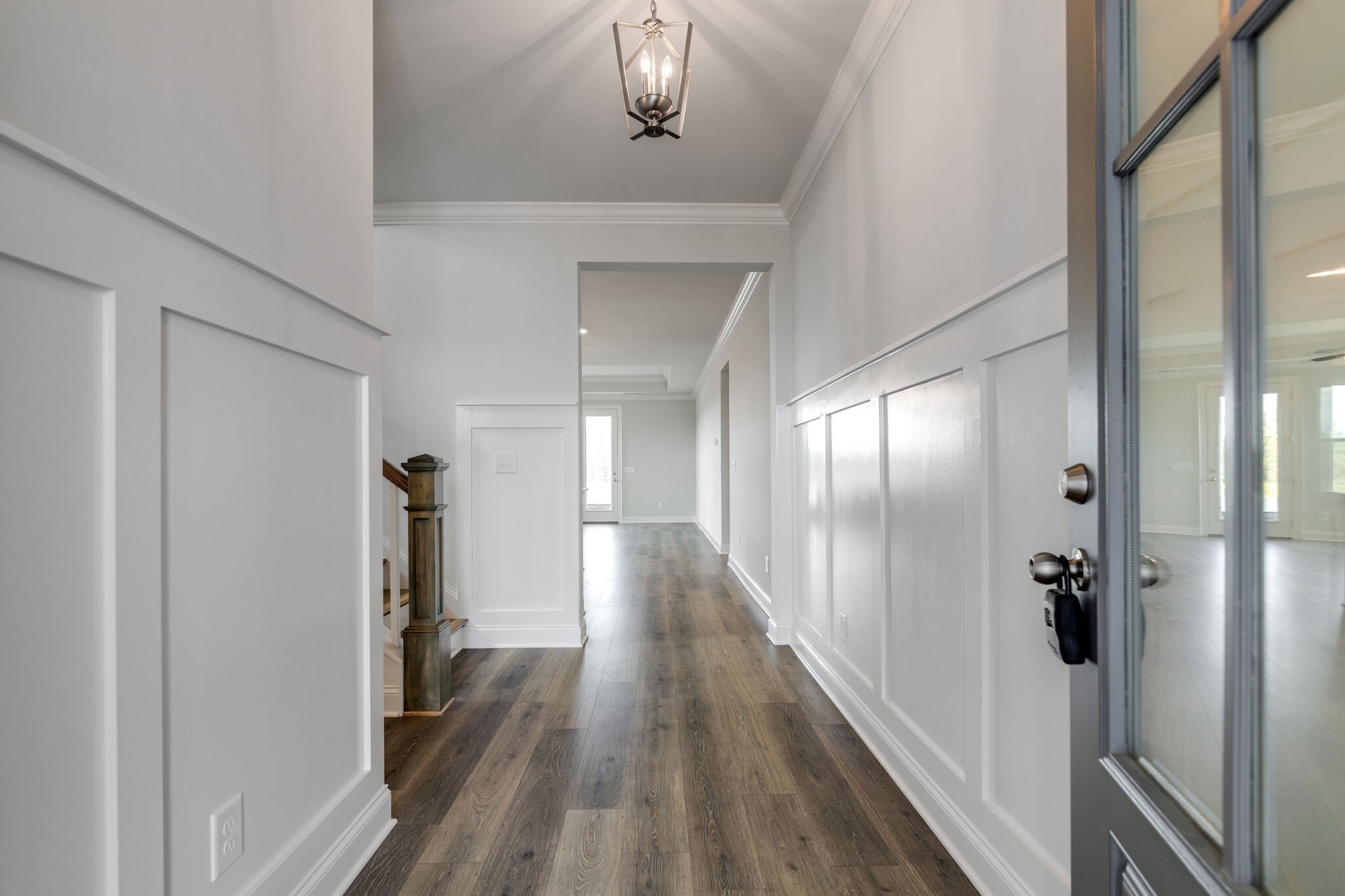 a view of a hallway with wooden floor and staircase