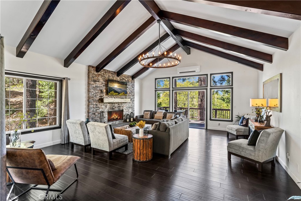 a living room with furniture large window and wooden floor