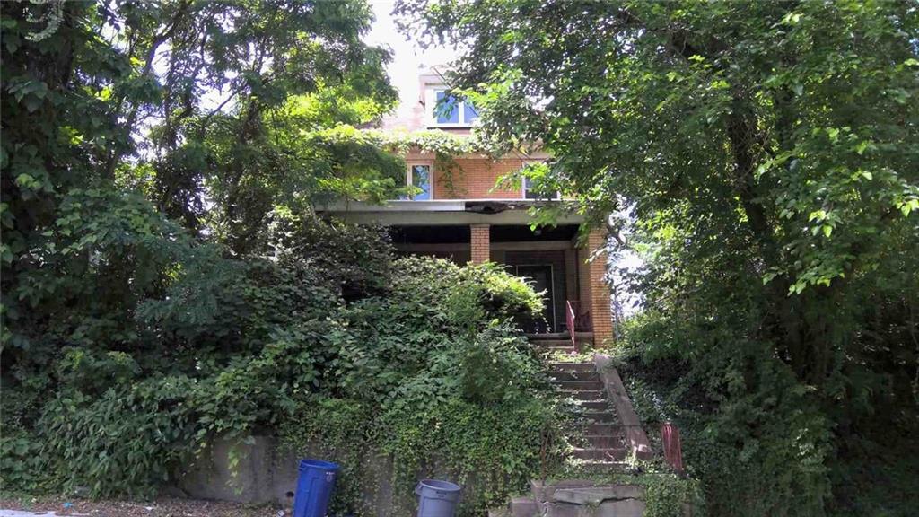 a front view of a house with a yard and fountain