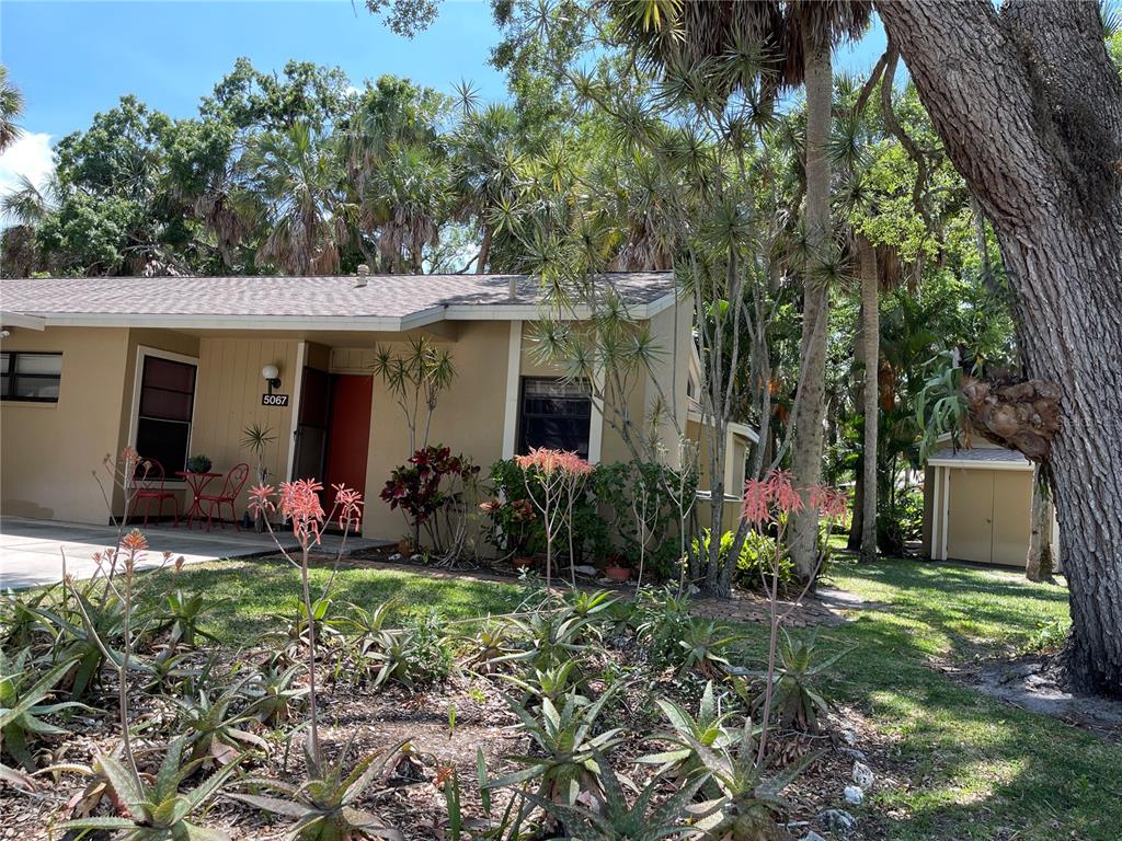 a front view of a house with a yard and potted plants