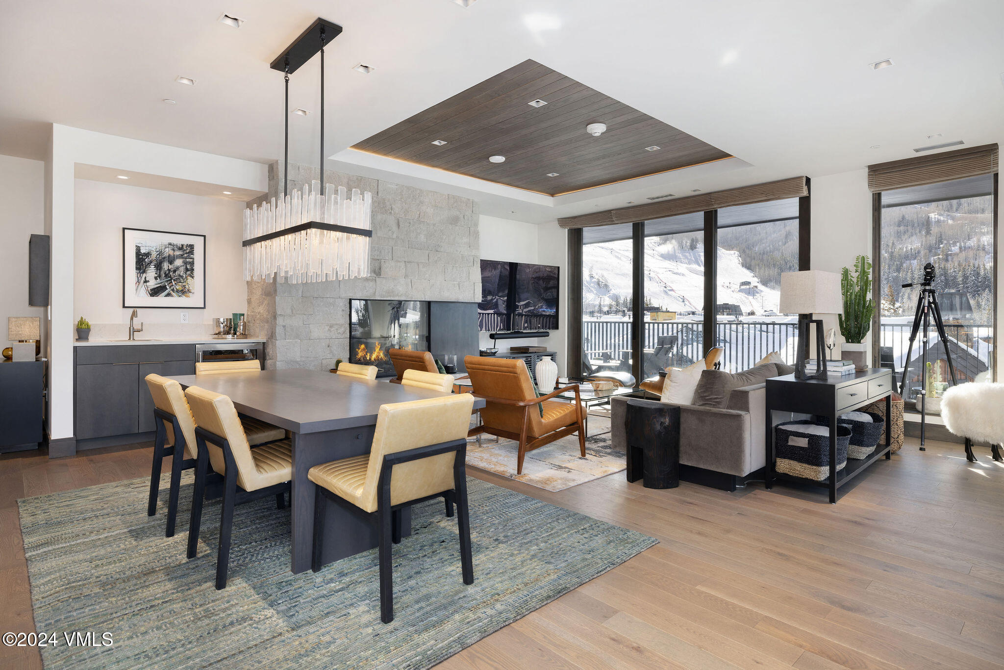 a living room with furniture kitchen view and large windows