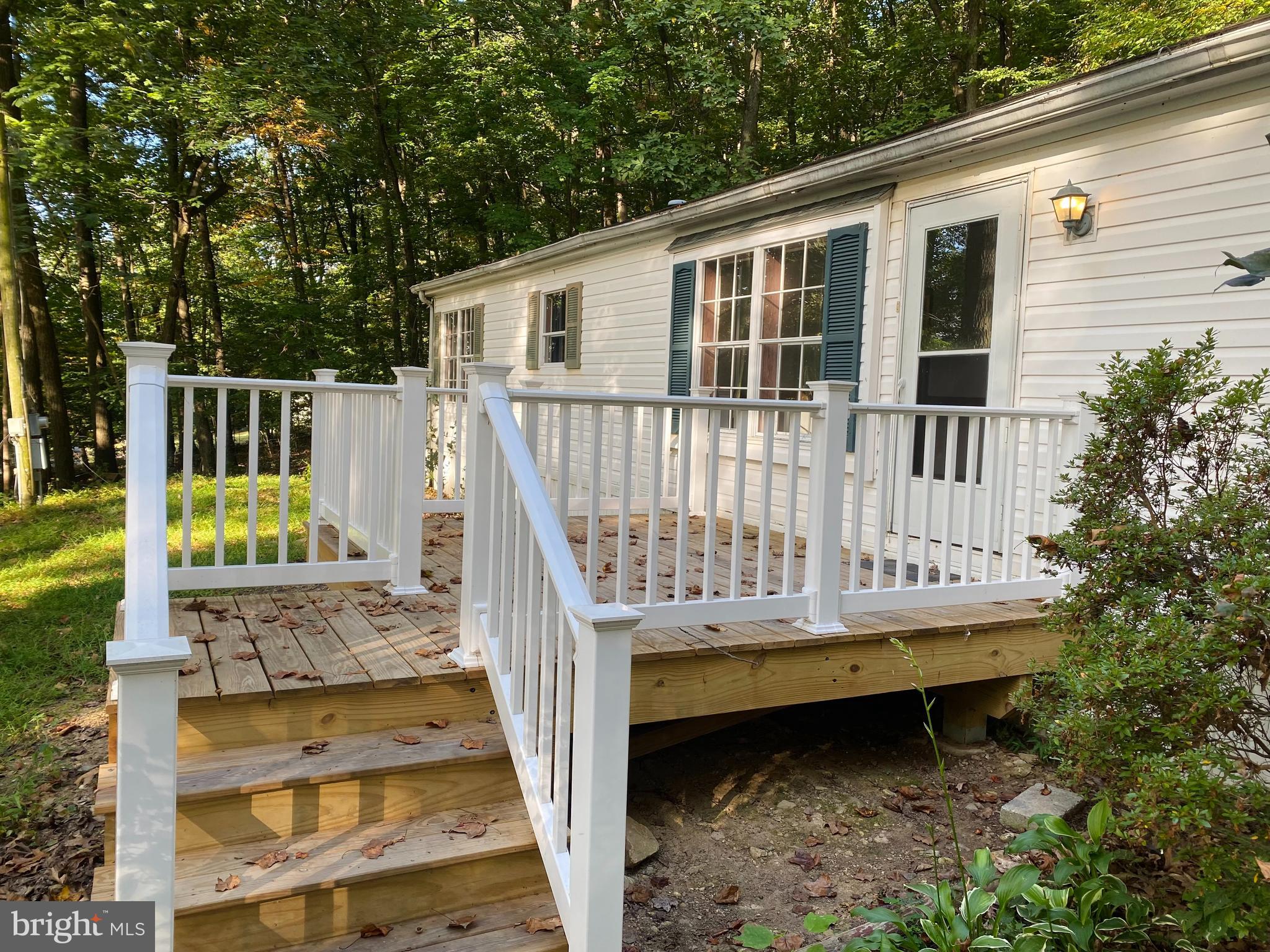 a view of a wooden deck and a yard with swimming pool