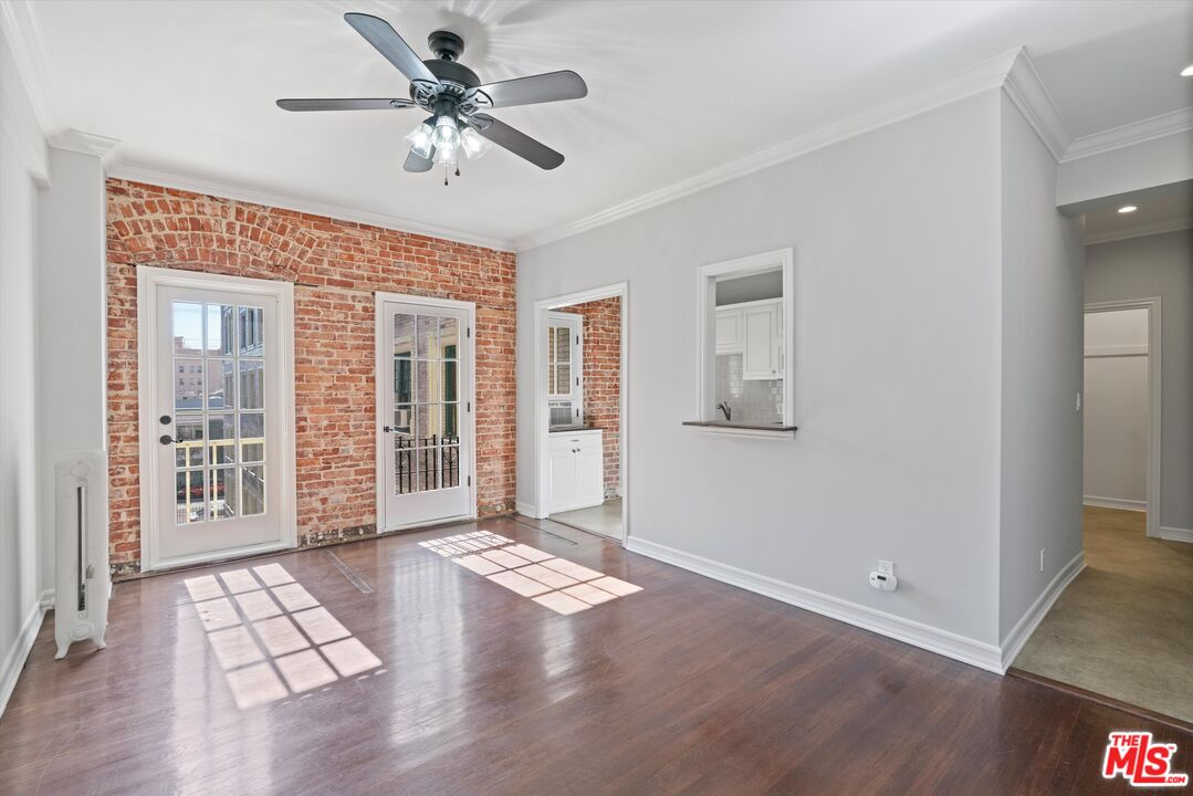 a view of an empty room with a window and a ceiling fan