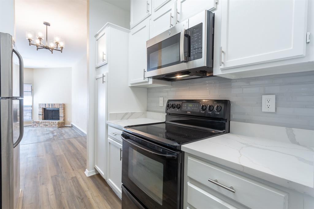 a kitchen with stainless steel appliances white cabinets and stove top oven