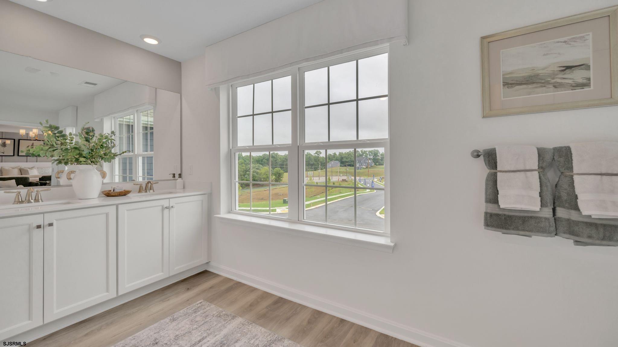 a kitchen with white cabinets and window