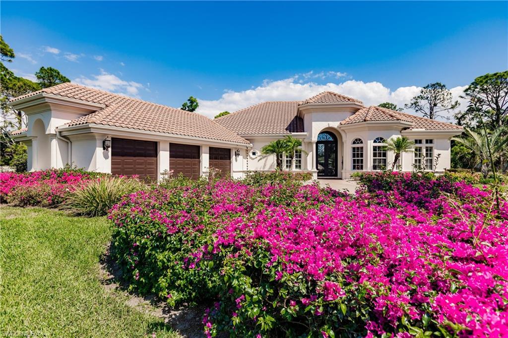 a front view of house and yard with beautiful flowers and house