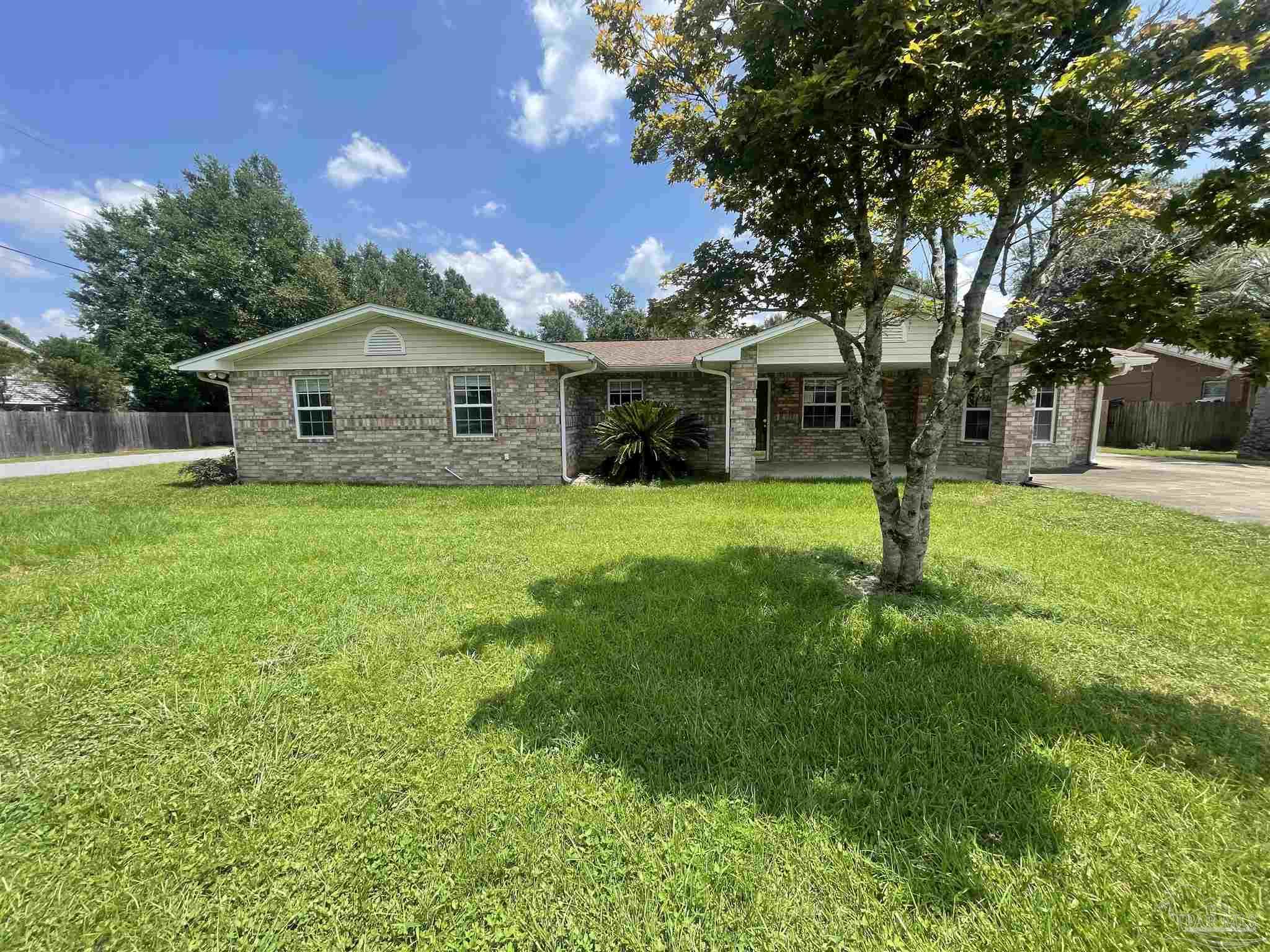 a front view of a house with a yard and trees