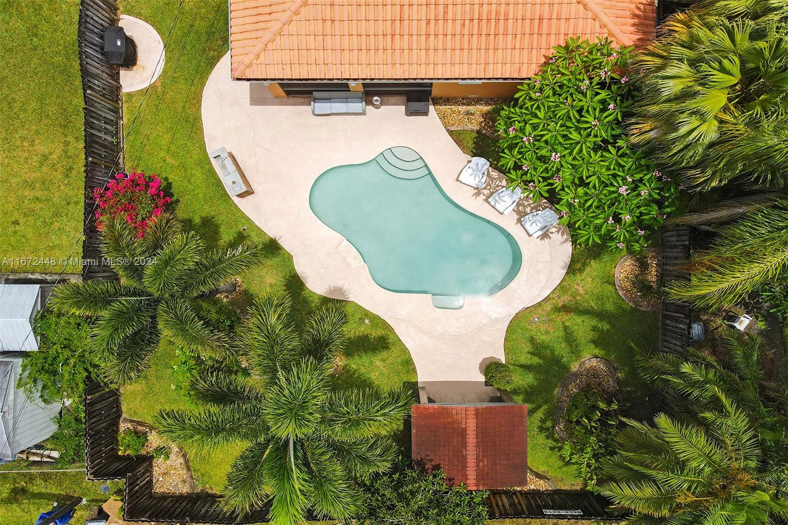 an aerial view of a house with swimming pool and garden